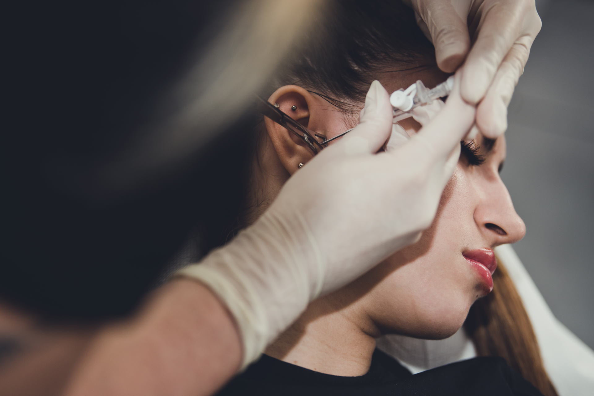 piercerka wykonuje przekłucie ucha TRAGUS