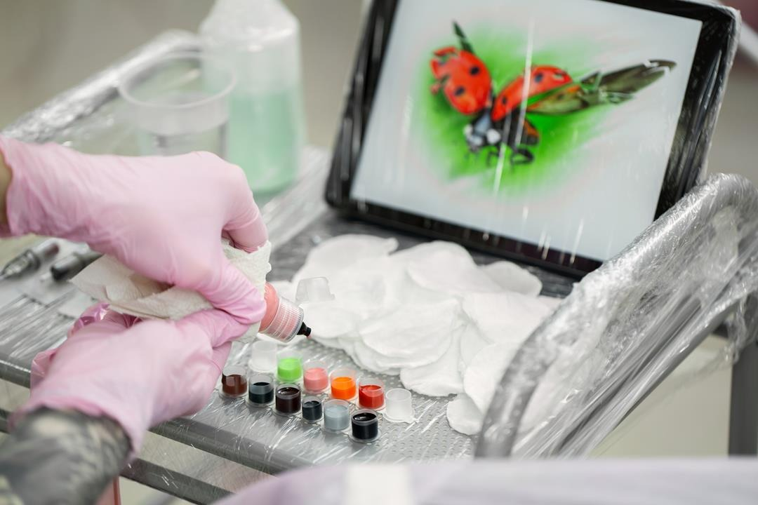 tatuator przygotowuje tusze do wykonania tatuażu z projektu AI